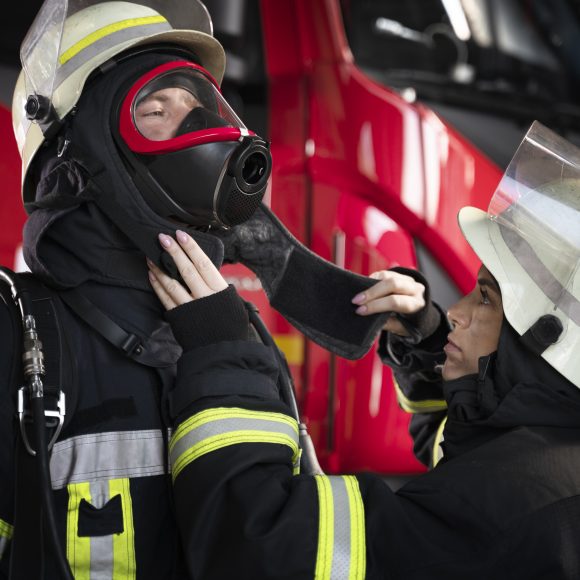 female firefighter adjusting her colleague s fire mask 580x580 1